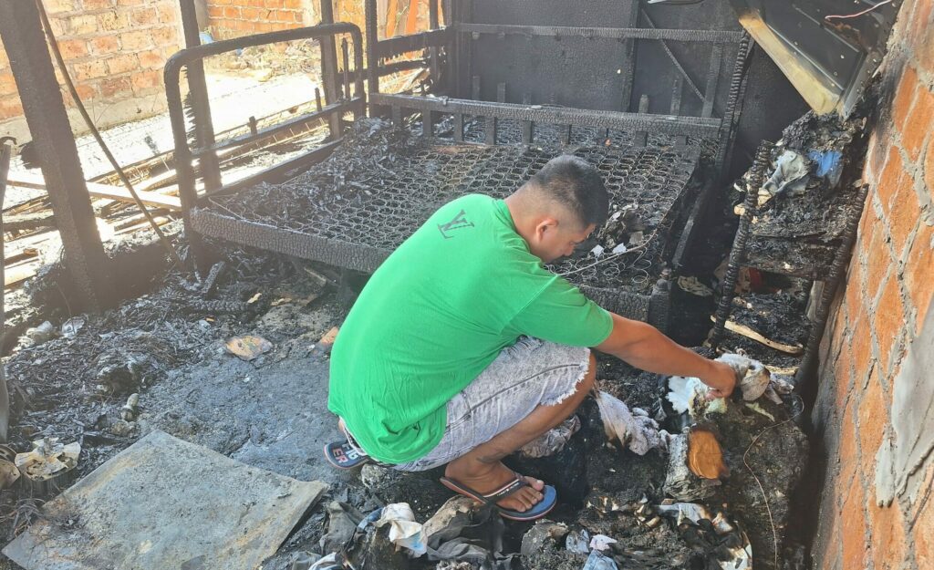 Juan Molina busca entre los escombros que dejó el incendio, algún artículo que le pueda servir.