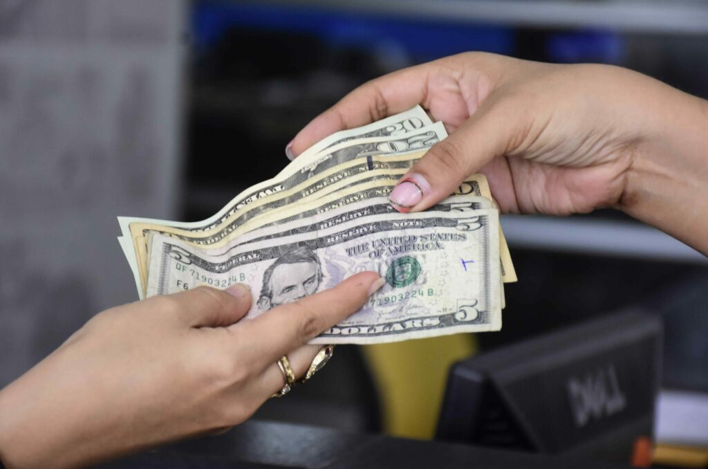 Imagen referencial que muestra el pago en efectivo por un servicio en el Ecuador