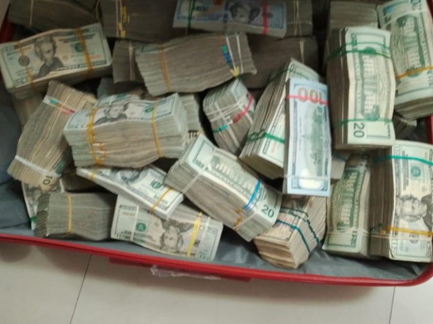 Una maleta llena de fajos de dinero se descubrió en la vivienda de una agente policial en servicio activo durante un allanamiento.