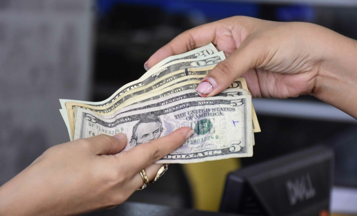 Imagen referencial que muestra el pago en efectivo por un servicio en el Ecuador