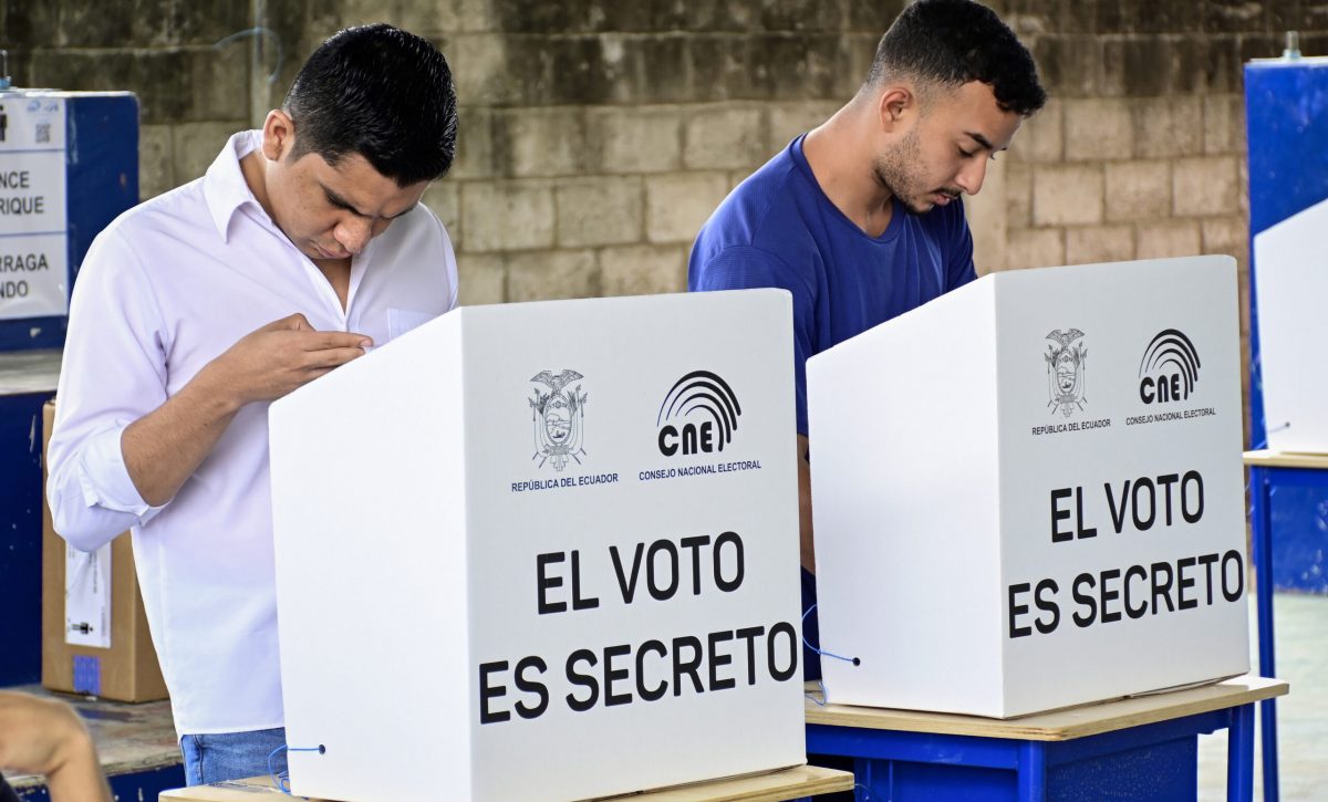 Dos hombres ejercen su voto en la Escuela 24  de Mayo de Portoviejo.