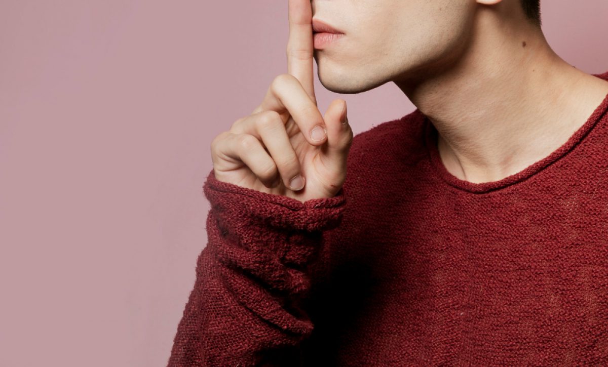 Persona haciendo gesto de silencio con el dedo sobre los labios, concepto del silencio electoral en Ecuador 2025.